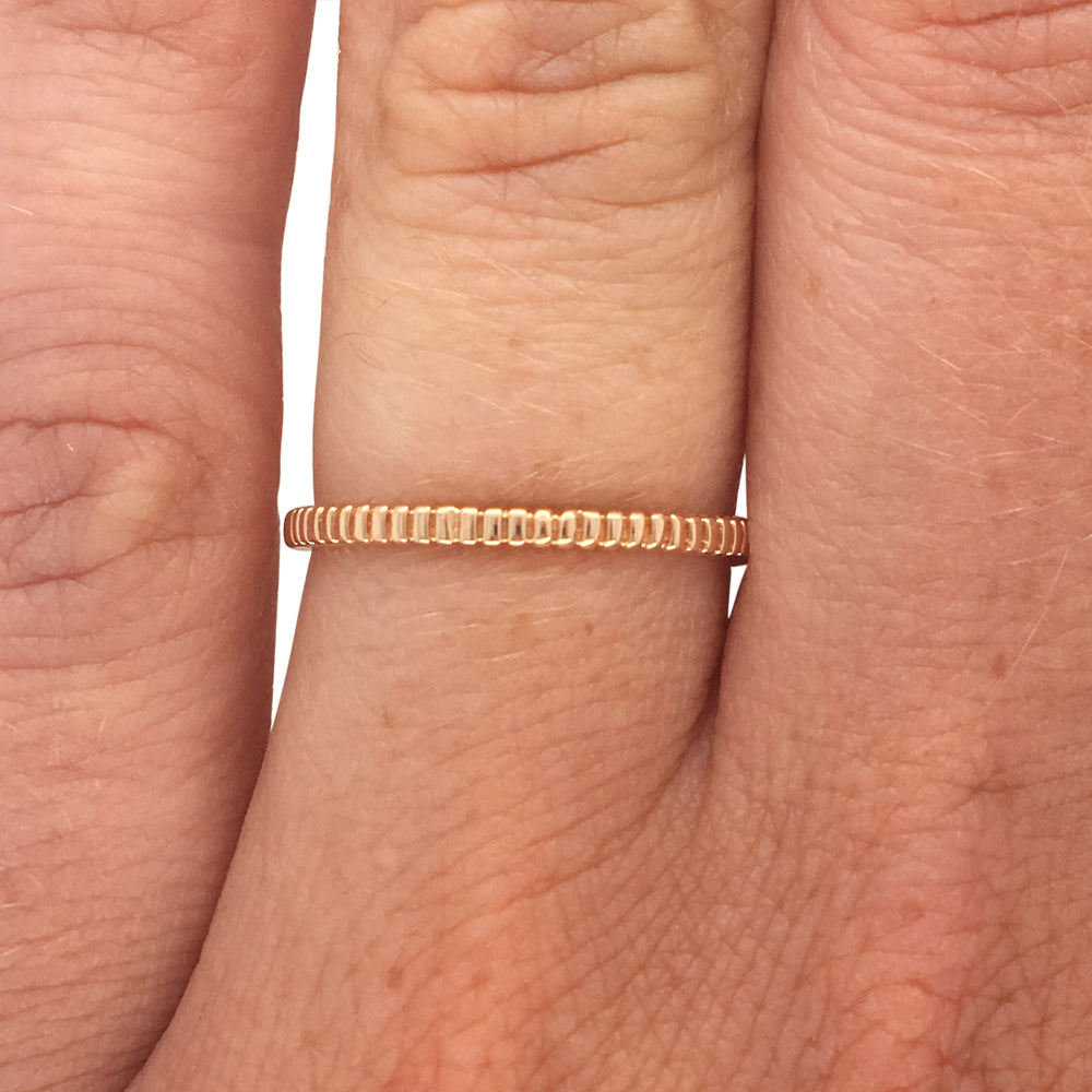 
                  
                    Load image into Gallery viewer, Ring with a lined pattern cast in 14 kt yellow gold on left ring finger.
                  
                