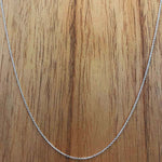 Front view of a sterling silver chain with a rich, wooden background.