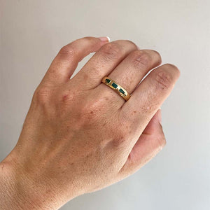 
                  
                    Load image into Gallery viewer, Front view on left middle finger of 4.6mm wide and rounded band with 3 inlays of malachite, rectangular in shape in the middle and tapered on either side. Cast in 14kt yellow gold.
                  
                