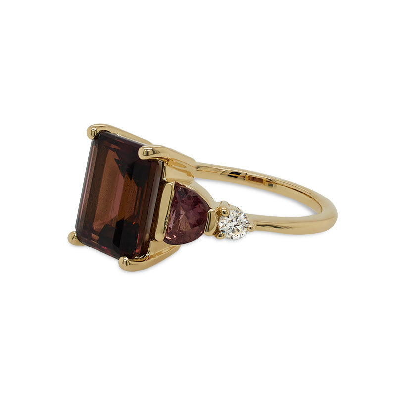
                  
                    Load image into Gallery viewer, Right side view of an asymmetrical, emerald cut deep red tourmaline ring with a half moon cut and round cut pink sapphires and diamonds cast in 14 kt yellow gold.
                  
                