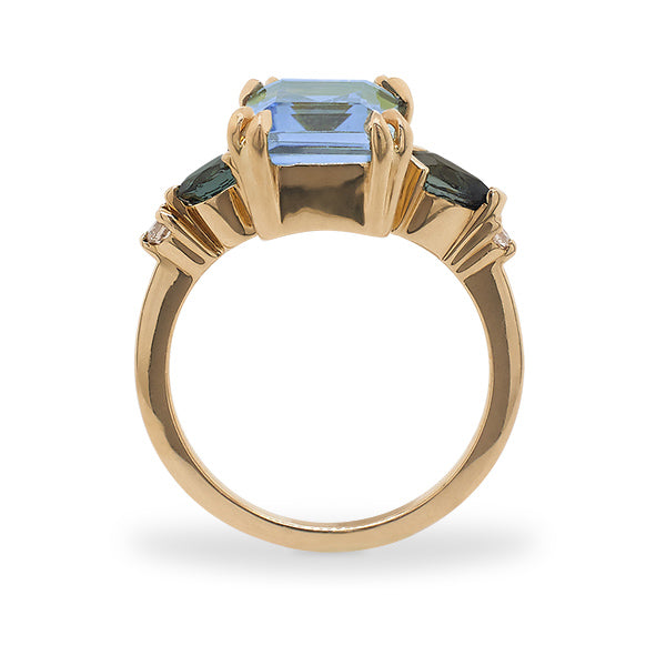 Side view of a large, emerald cut topaz, tourmaline and diamond ring cast in 14 kt yellow gold.