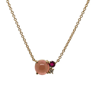 
                  
                    Load image into Gallery viewer, Front view of a cabochon cut, pink tourmaline necklace with one round cut, faceted, deep red tourmaline and one round cut diamond necklace cast in 14 kt yellow gold.
                  
                