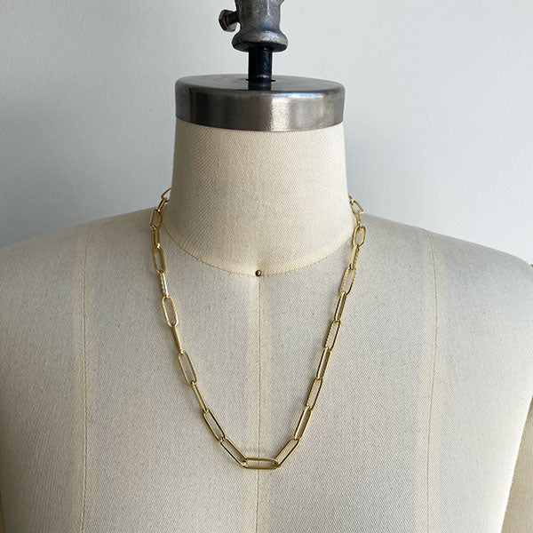 
                  
                    Load image into Gallery viewer, Front view of paperclip chain on dress form, cast in 14kt yellow gold.
                  
                