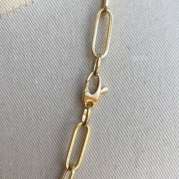 
                  
                    Load image into Gallery viewer, Close up image of paperclip links and oval lobster clasp closure in 14kt yellow gold.
                  
                