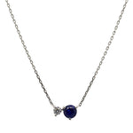 Front view of a round cut blue sapphire and diamond necklace made of solid 14 kt white gold.