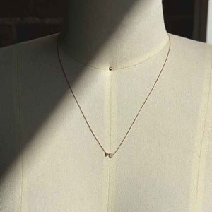 
                  
                    Load image into Gallery viewer, An east west set opal and 0.06 ct. white diamond pendant necklace cast in 14k rose gold on a body form for scale.
                  
                