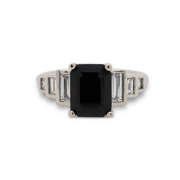 Front view of emerald cut black sapphire ring with 6 baguette cut diamonds set in 14 kt white gold.
