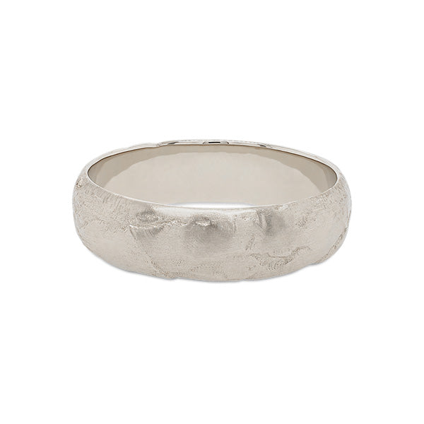 
                  
                    Load image into Gallery viewer, Front view of a 6.5 mm wide rounded band with an organic texture cast in 14 kt white gold.
                  
                