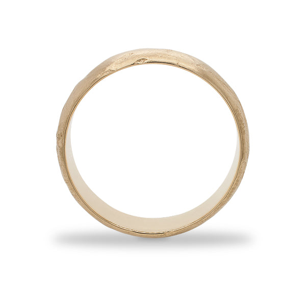 SIde view of a 6.5 mm wide rounded band with an organic texture cast in 14 kt yellow gold.