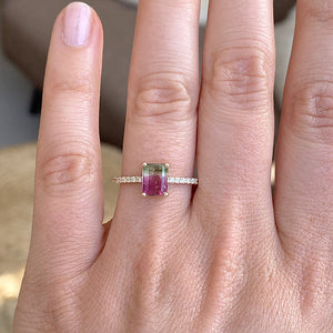 
                  
                    Load image into Gallery viewer, An emerald cut watermelon tourmaline ring flanked by 16 round cut diamonds and cast in 14 kt yellow gold on wearer&amp;#39;s left ring finger for scale.
                  
                