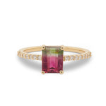 Front view of an emerald cut watermelon tourmaline ring flanked by 16 round cut diamonds and cast in 14 kt yellow gold.