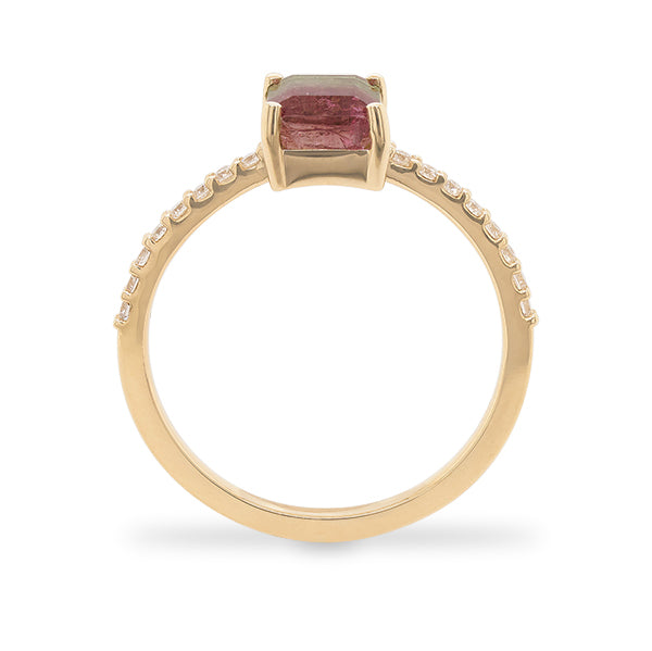 Side view of an emerald cut watermelon tourmaline ring flanked by 16 round cut diamonds and cast in 14 kt yellow gold.